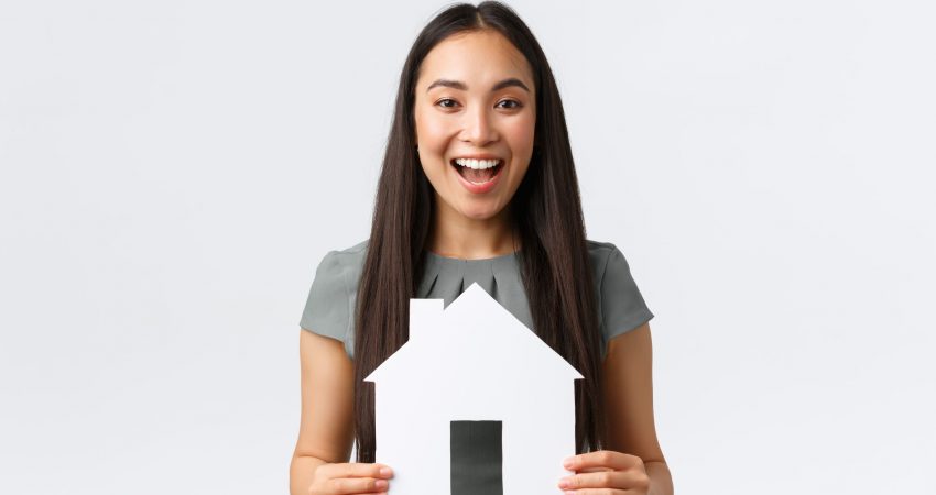 Insurance, loan, real estate and family concept. Cheerful asian female buying or selling home, holding paper house and smiling upbeat, searching for new apartment, white background Insurance, loan, real estate and family concept. Cheerful asian female buying or selling home, holding paper house and smiling upbeat, searching for new apartment, white background.